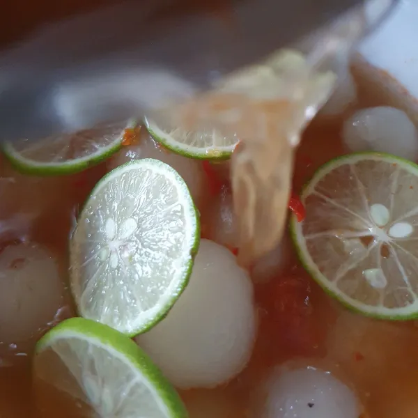 Siapkan rambutan, beri irisan jeruk nipis dan air peras. Tuang rebusan bumbu.