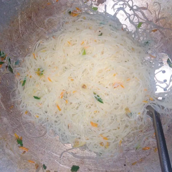 Masukan bihun dan air secukupnya, tambahkan garam, kaldu dan lada, aduk rata. Masak sampai air kering dan bihun matang, koreksi rasa bila sudah pas rasanya beri taburan daun seledri dan matikan api. Bihun goreng kampung siap disajikan dengan taburan bawang goreng di atasnya .