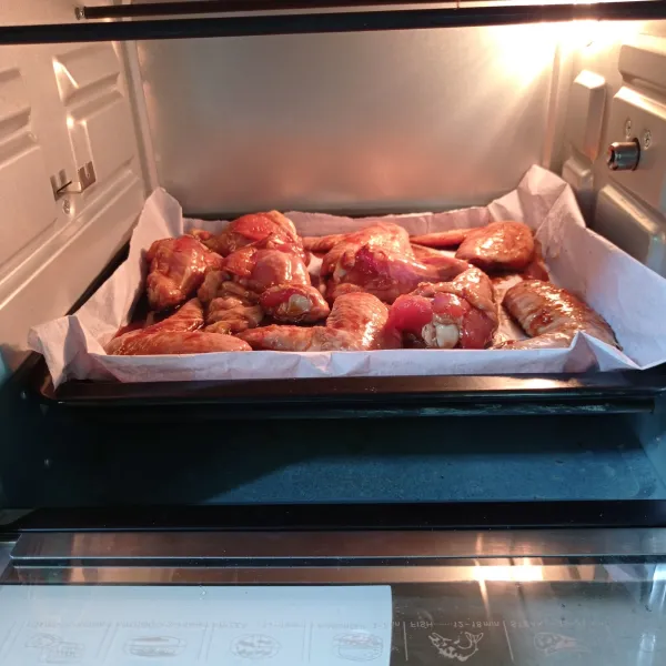 Tata sayap ayam pada loyang yang dilapisi kertas roti, panggang pada suhu 180 derajat selama 20 menit. Kemudian balik ayam panggang lagi selama 15 menit menggunakan api atas bawah dan oven sebelumnya dipanaskan terlebih dahulu.