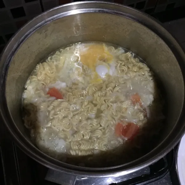 Masukkan mie instan, tomat, dan telur, masak sampai mie matang sesuai selera