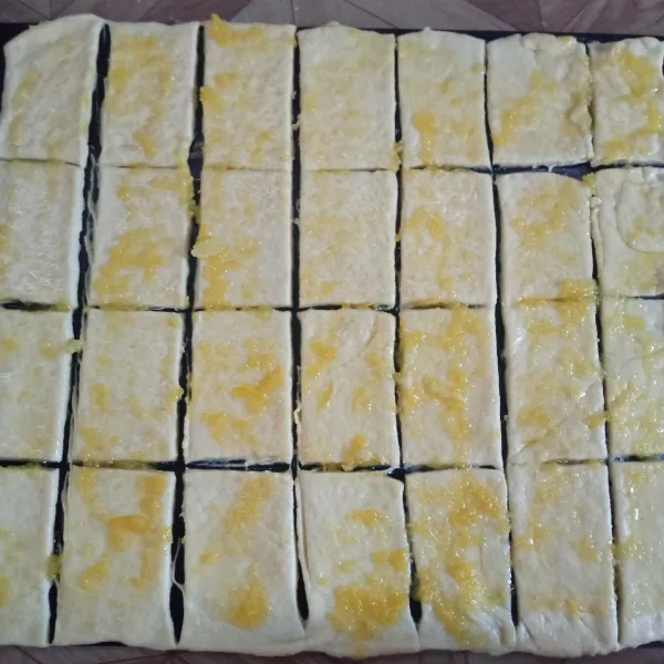 Oleskan garlic butter pada permukaan dough. Lalu potong persegi panjang dough tersebut seperti di gambar.