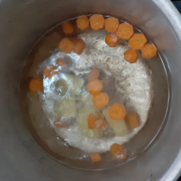 Didihkan air dalam panci, masukan wortel dan kentang, masak hingga empuk.