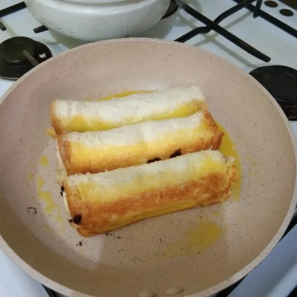 Panaskan margarin, tata gulungan roti di atasnya, bolak balik hingga semua sisi roti kecokelatan