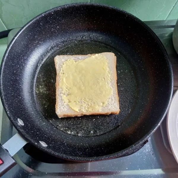 Tutup dengan selembar roti tawar dan oles margarin di bagian atasnya.