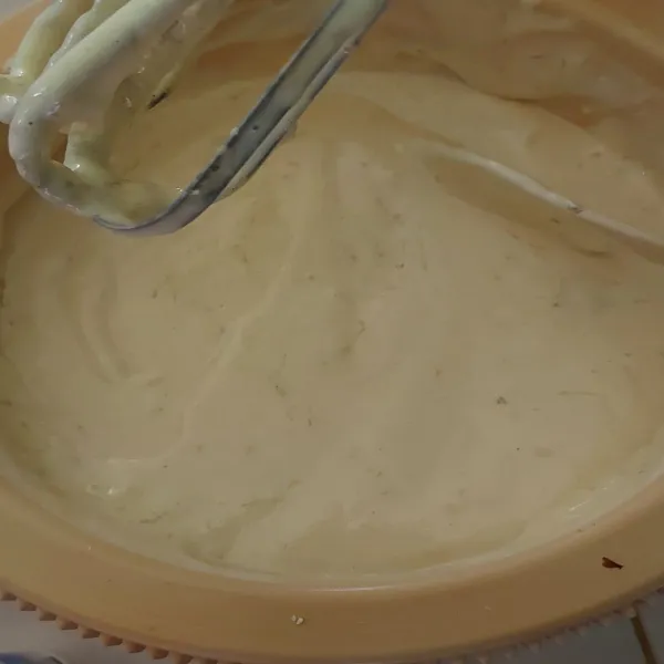 Hentikan mixer, kemudian masukan mentega yang sudah dicairkan secara perlahan, lalu aduk menggunakan sendok adonan hingga adonan tercampur merata