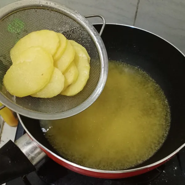 Setelah ditiriskan, goreng kembali kentang dengan api yang besar. Angkat dan siap disajikan.