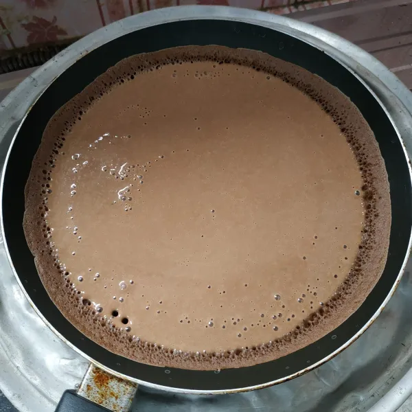 Panaskan teflon ukuran 22cm, tuang 1/2 adonan kedalam teflon dan biarkan sampai keluar gelembung-gelembung dan bersarang.