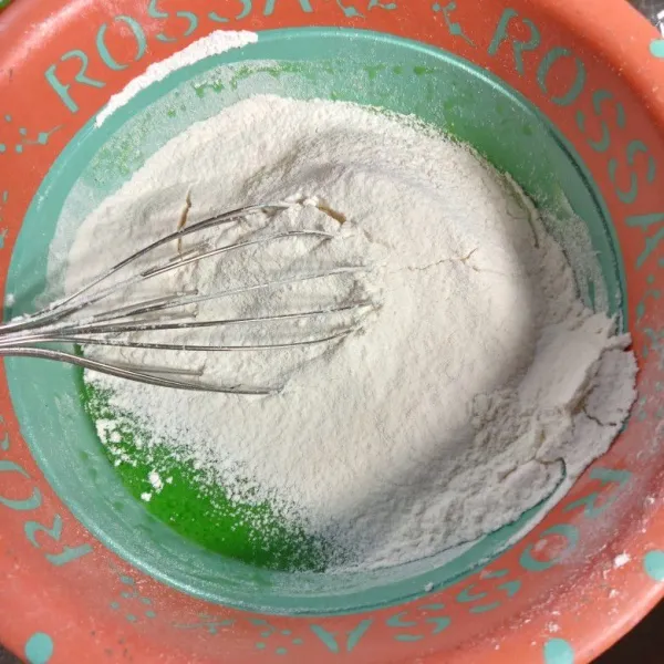 Ayak tepung terigu dan baking powder diatas adonan, lalu aduk hingga adonan licin.