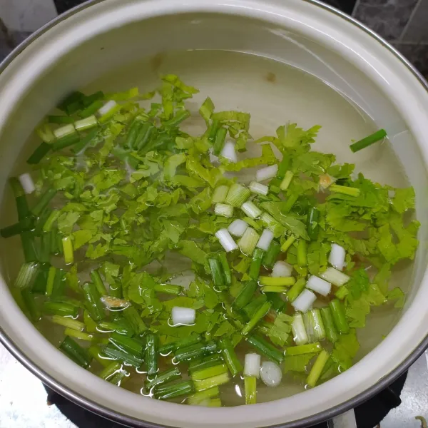 Rebus air bersama irisan daun bawang, seledri, dan bawang putih cincang sampai mendidih.