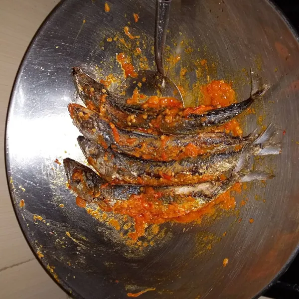 Setelah air menyusut, masukan ikan goreng . Aduk hingga tercampur rata dengan bumbu. Matikan api