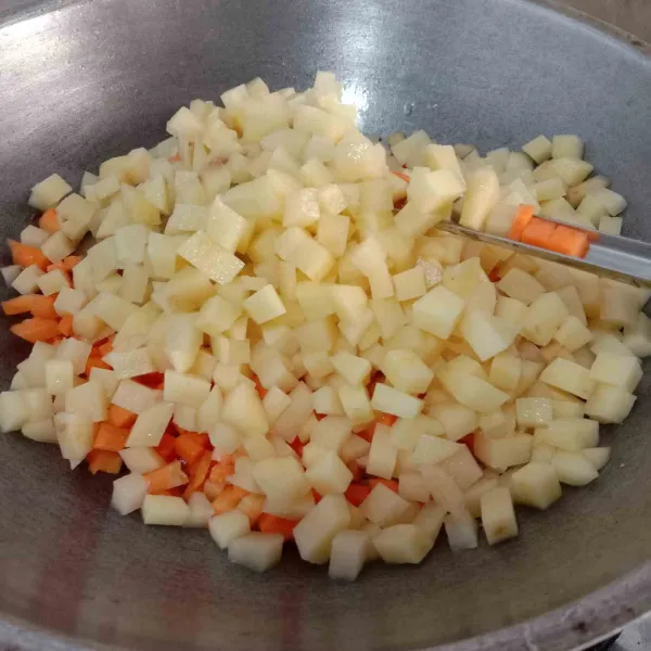 Masukkan kentang dan wortel yang sudah dipotong dadu kecil dan sudah di cuci bersih ke dalam wajan.