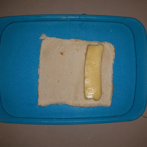 Olesi pinggiran roti tawar dengan putih telur. Letakan keju mozarella kemudian gulung. Tekan agar merekat.