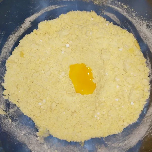 Setelah adonan tercampur dan berpasir, tambahkan kuning telur. Uleni hingga tercampur rata, tidak perlu kalis. Apabila susah tercampur, tambahkan ± 3 sdm air dingin.