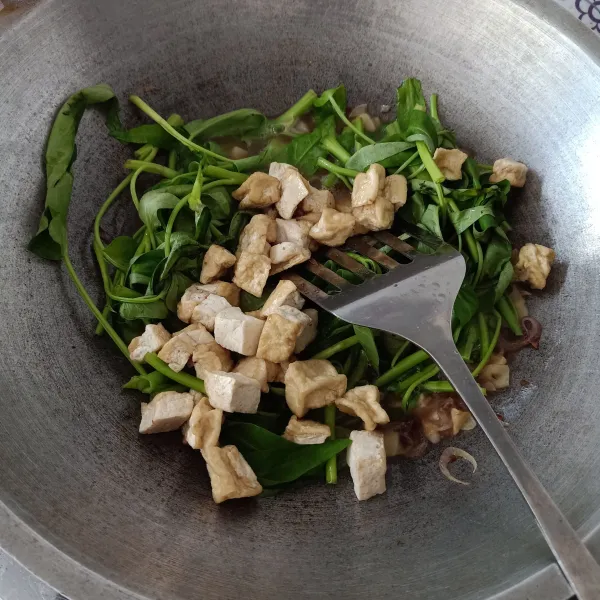 Masukkan tahu yang sudah digoreng, aduk rata.