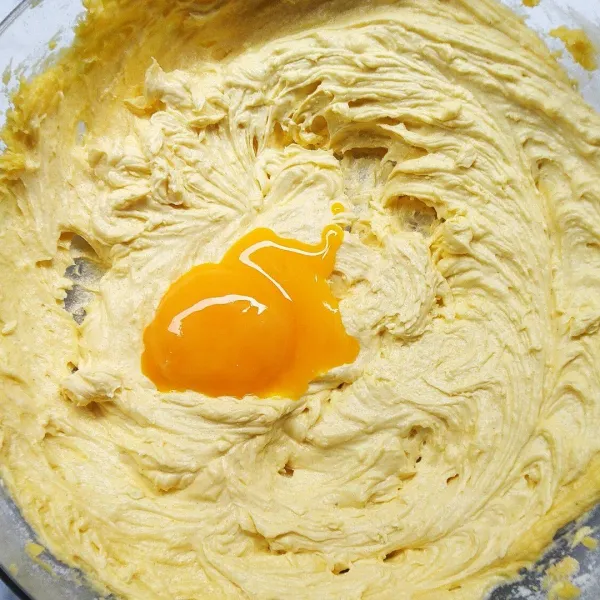 Masukkan kuning telur secara bertahap. Mixer hingga teraduk rata.