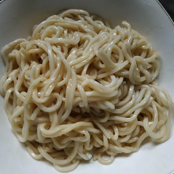 Siapkan mangkuk tuang 2 sdm minyak ayam dan 1 sdm kecap asin, masukan mie lalu aduk hingga rata.