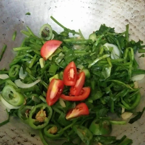Tambahkan irisan tomat dan bawang daun masak hingga kematangan yang diinginkan