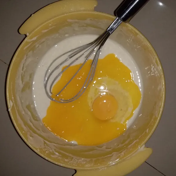 Masukan margarin, baking soda dan telur. Aduk adonan hingga tidak bergerindil.