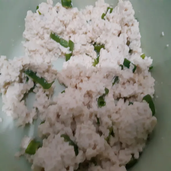 Hancurkan tahu menggunakan sendok, beri potongan daun bawang, tambahkan garam, lada dan penyedap. Aduk