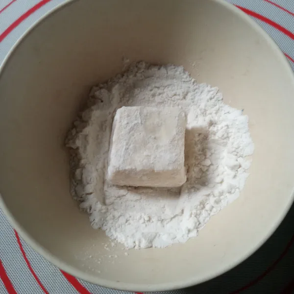 Gulingkan tahu ke tepung jagung sampai semua permukaan tahu terlapisi tepung.