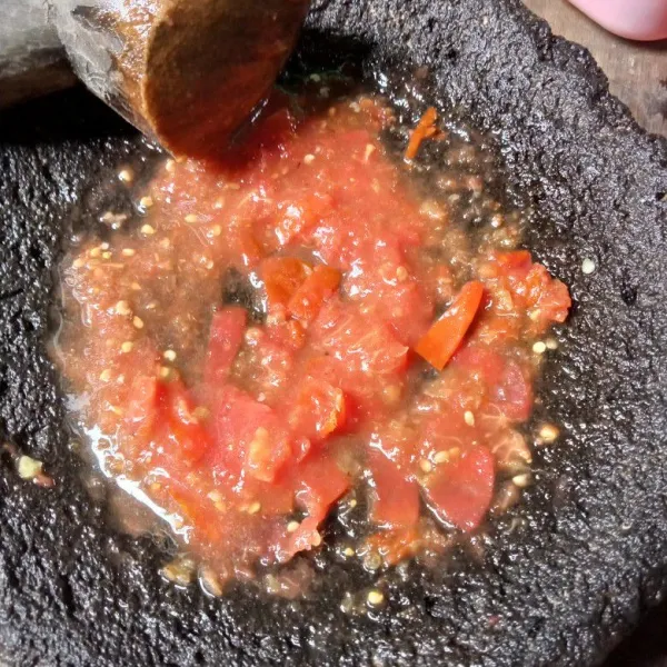 Masukkan irisan tomat dan ulek lagi sampai halus.