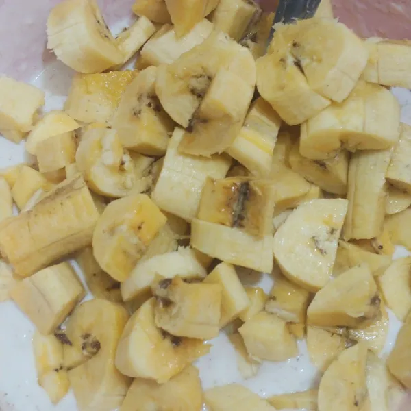 Potong kecil-kecil pisang, lalu campur dengan tepung. Aduk rata.