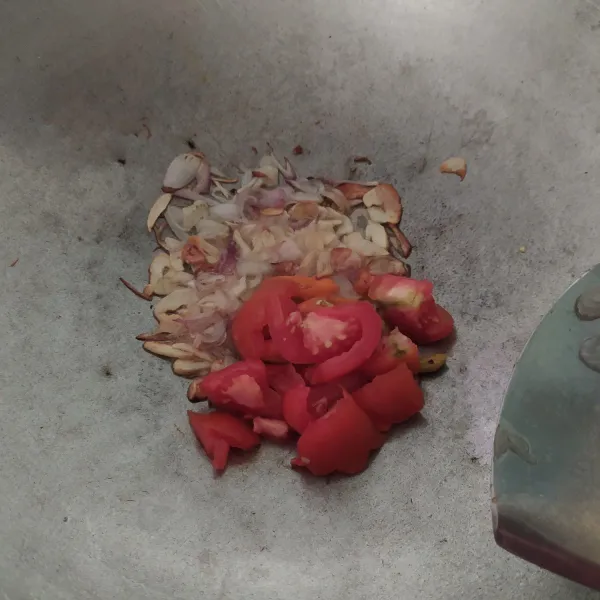 Setelah harum masukkan potongan tomat dan cabai rawit merah, aduk aduk hingga rata
