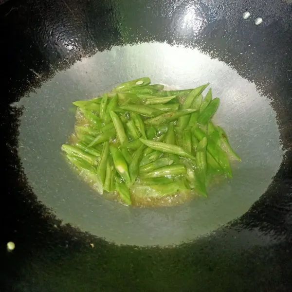 Siapkan wajan lalu beri minyak sedikit untuk tumis irisan bawang merah dan bawang putih. Tumis sampai tercium harum lalu masukkan irisan buncis.