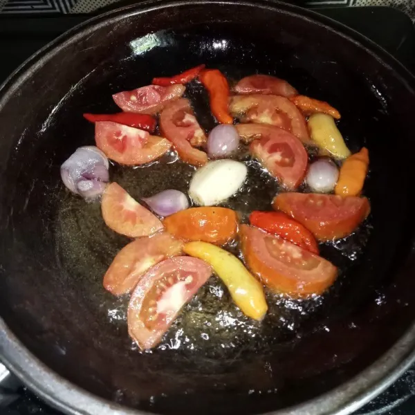 Goreng bawang merah, bawang putih, cabai dan tomat hingga layu.