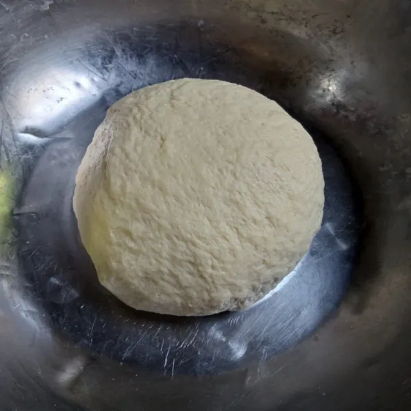 Masukkan mentega dan garam, uleni lagi hingga adonan kalis elastis, lalu tutup dan diamkan adonan hingga mengembang dua kali lipat.