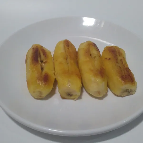 Belah bagian tengah pisang jangan sampe putus.