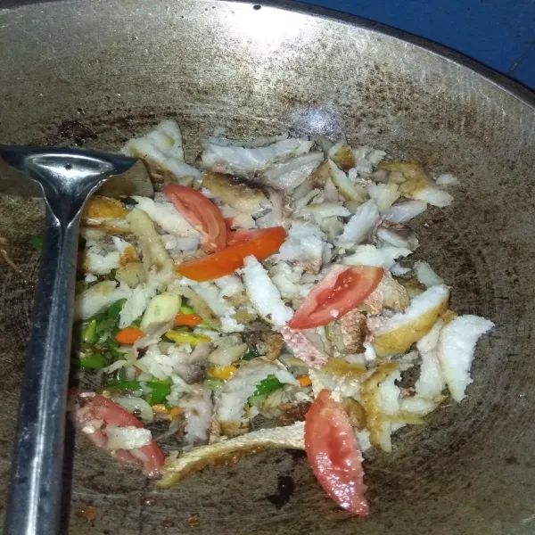 Masukkan irisan ikan kakap, tomat potong dan irisan daun bawang, aduk rata