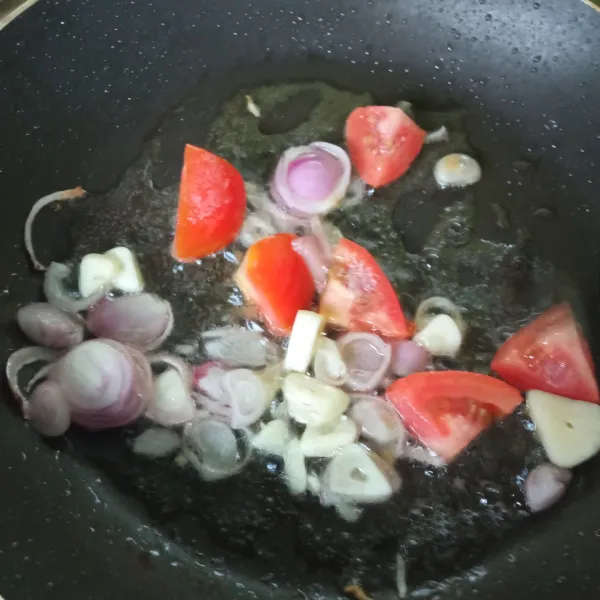 Siapkan wajan, tuang minyak, lalu tumis bawang merah, bawang putih dan tomat.