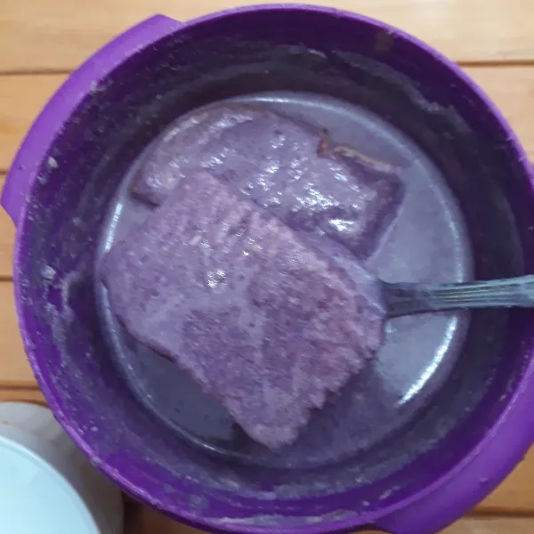 Celupkan potongan roti ke dalam adonan ubi ungu hingga meresap.
