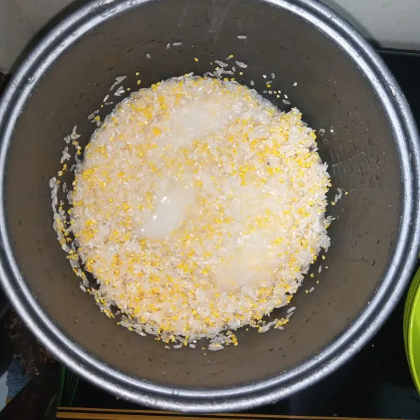 Cuci beras seperti biasa. Masukkan jagung, aduk rata bersama beras. Tambahkan air setinggi 2 ruas jari. Masak menggunakan magicom seperti biasa.