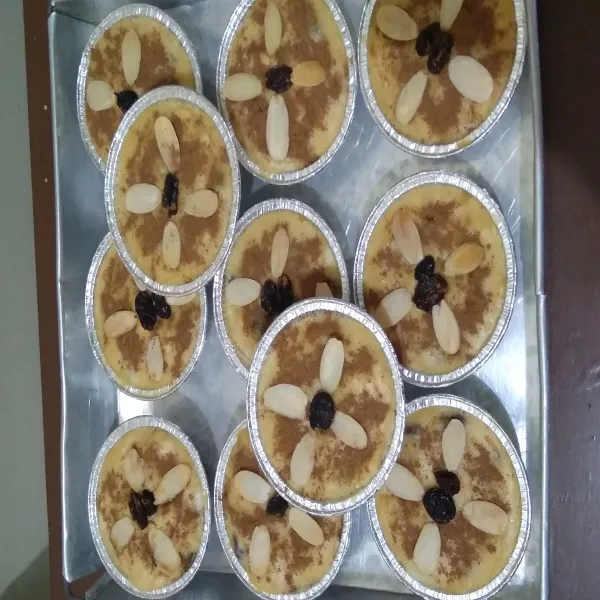 Beri taburan bubuk kayu manis, kismis dan almond slice. Panggang/oven selama kurang lebih 15 menit. Klappertaart siap untuk disajikan.
