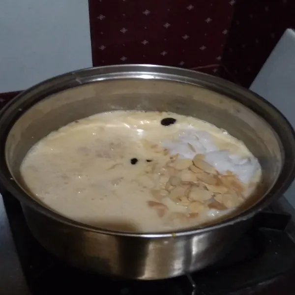 Masukkan kelapa muda yang sudah dikerok isinya, kismis, kacang almond, mentega, dan vanilla. Aduk rata sampai mengental.