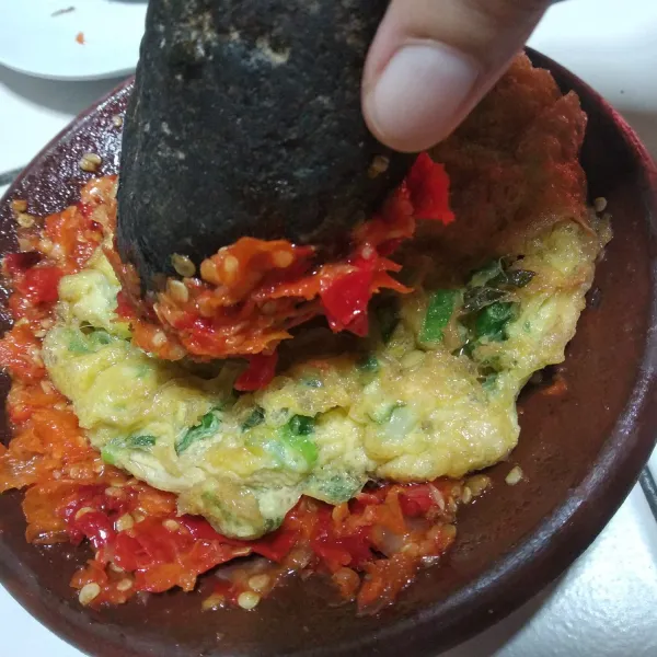 Masukkan telur, aduk dengan sambal sambil diulek perlahan. Siap disajikan dengan bahan pelengkap.