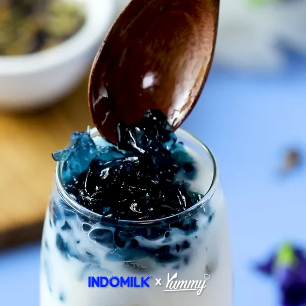 Masukkan es batu, simple sirup, Indomilk Vanilla Marie, dan jelly telang ke dalam gelas saji.