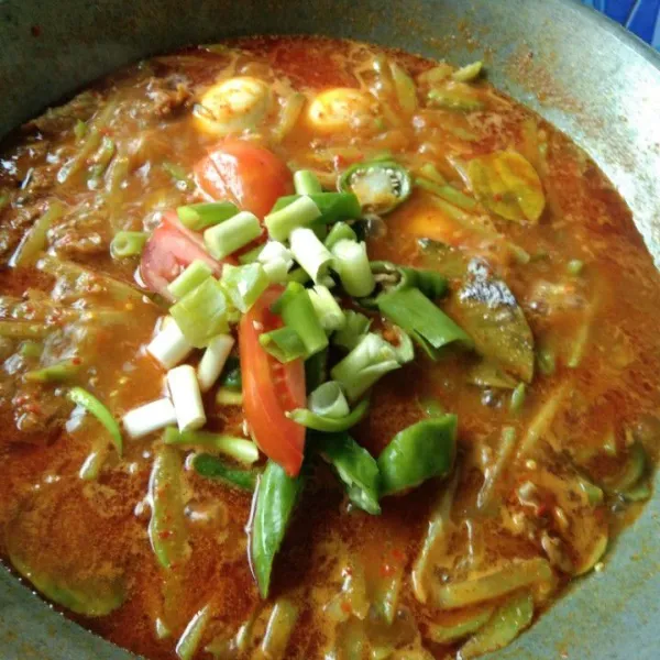 Tambahkan irisan tomat, cabe hijau dan bawang daun, masak hingga bawang daun layu