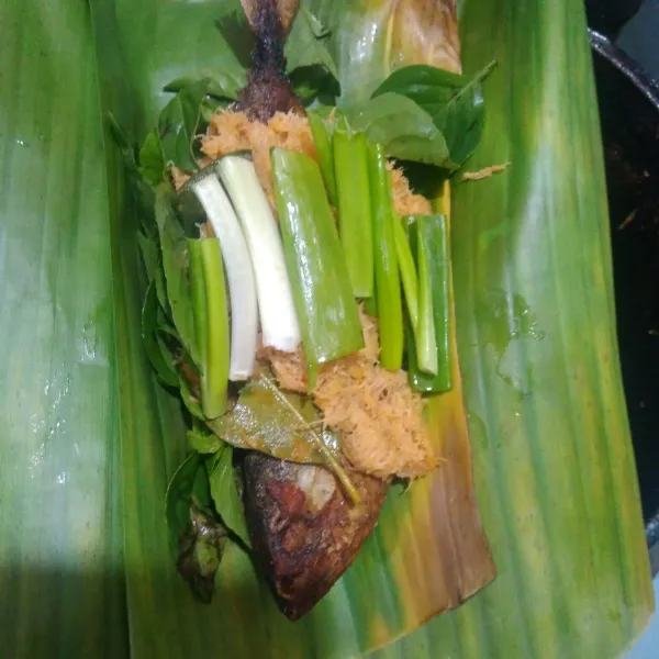 Siapkan daun pisang, kemudian tata di atasnya, kemangi, daun bawang, tumisan kelapa, ikan peda goreng lalu kelapa lagi. Jika suka tambahkan cabe rawit.