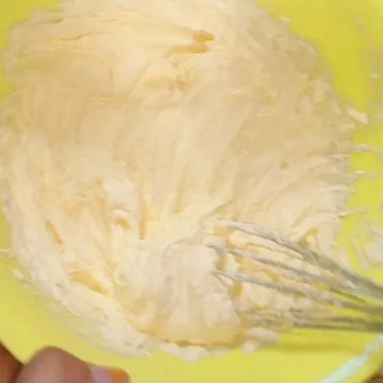 Masukan ke wadah margarin dan gula halus, kocok dengan wisk hingga berwarna kuning pucat