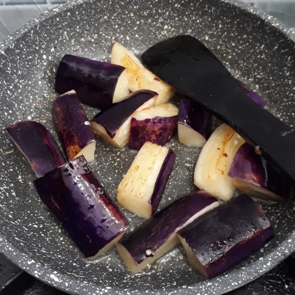 Panaskan secukupnya minyak lalu goreng terong ungu asal layu saja.