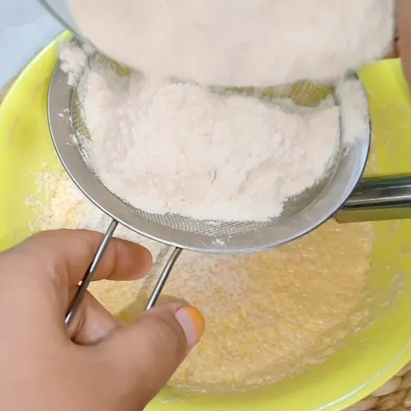 Masukan tepung terigu bertahap sambil diayak dan diaduk dengan sptula