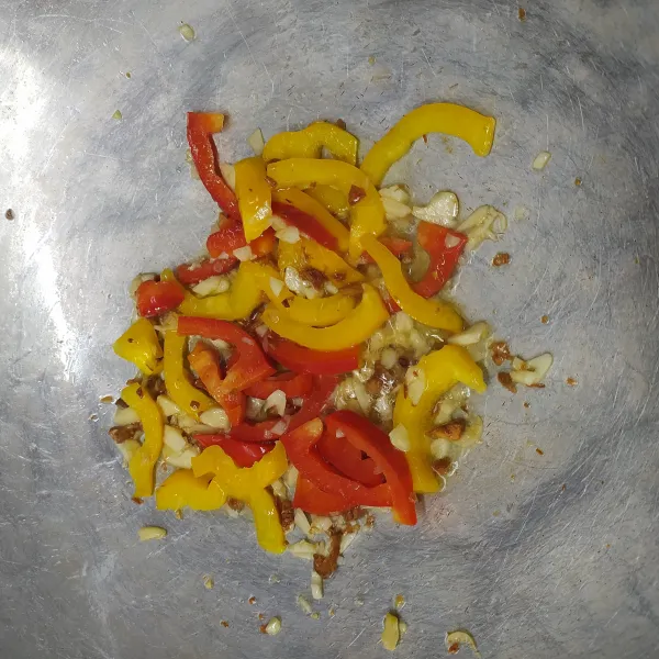 Panaskan minyak, tumis bawang putih cincang, paprika merah dan paprika kuning sampai harum dan layu