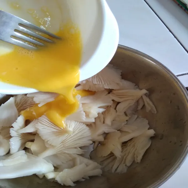 Potong dan cuci bersih jamur tiram, tiriskan. Lalu masukkan kocokan telur kedalamnya.