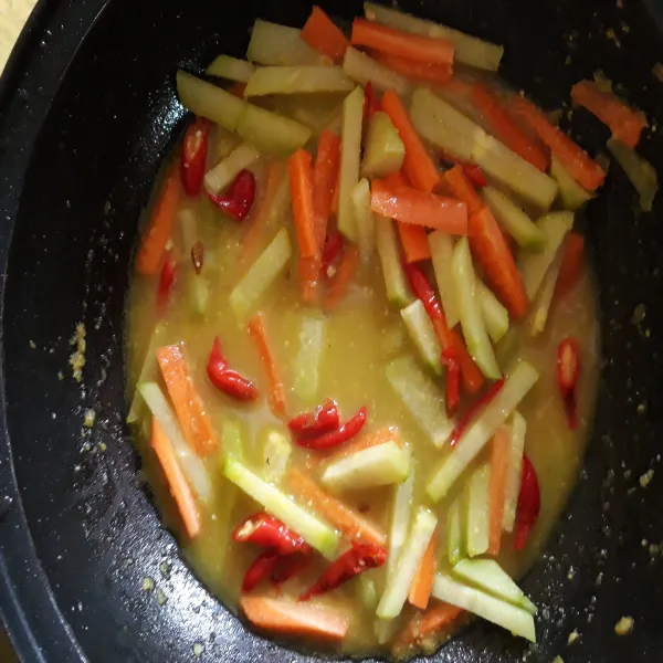 Masukkan labu siam dan wortel. beri air serta tambahkan garam dan kaldu bubuk. masak hingga kuah menyusut dan sayuran empuk.