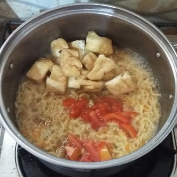 Masukkan tahu apung dan tomat. Aduk rata.