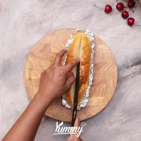 Siapkan roti yang telah dialasi dengan aluminium foil lalu belah roti menjadi dua bagian tidak putus.
