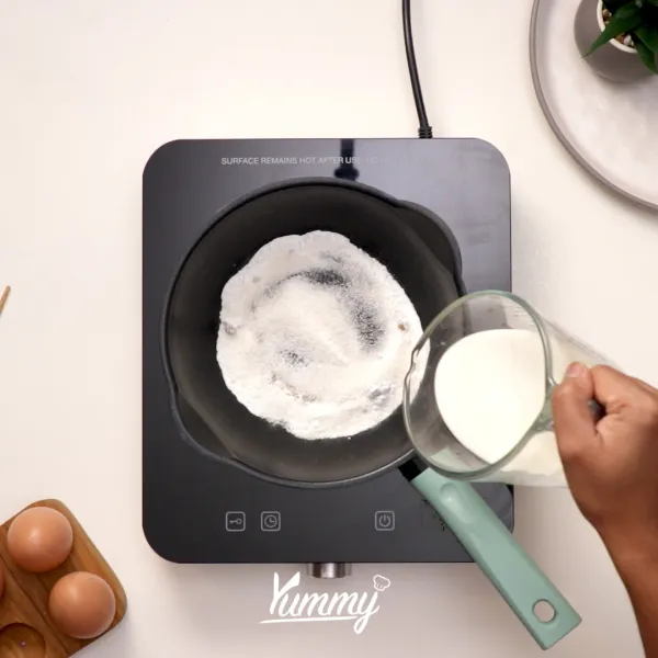 Tuangkan susu evaporasi dan whipping cream ke dalamnya lalu aduk kembali hingga tercampur rata.